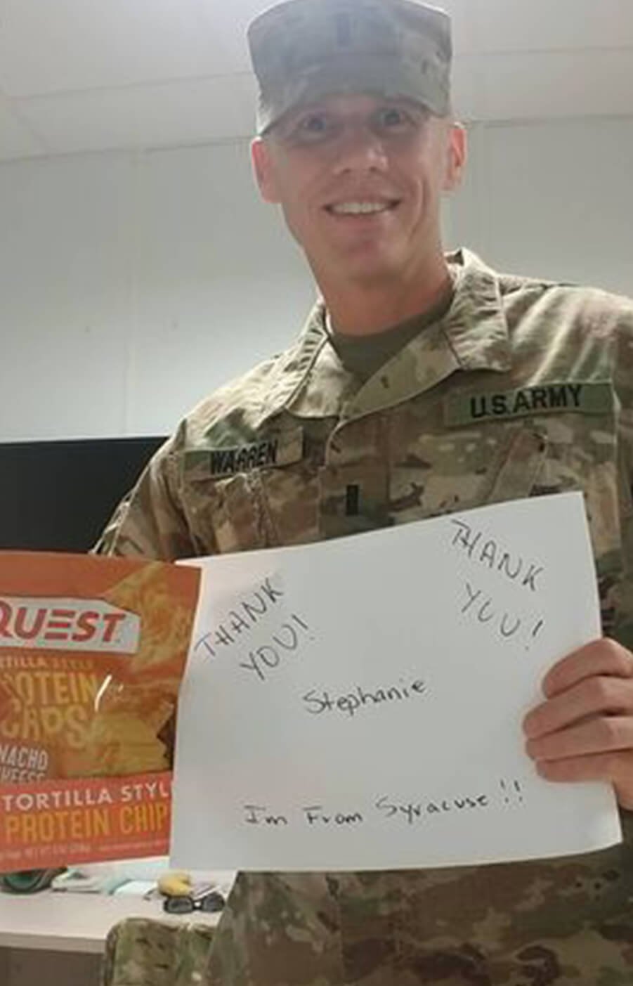 Troop holding care package and sign